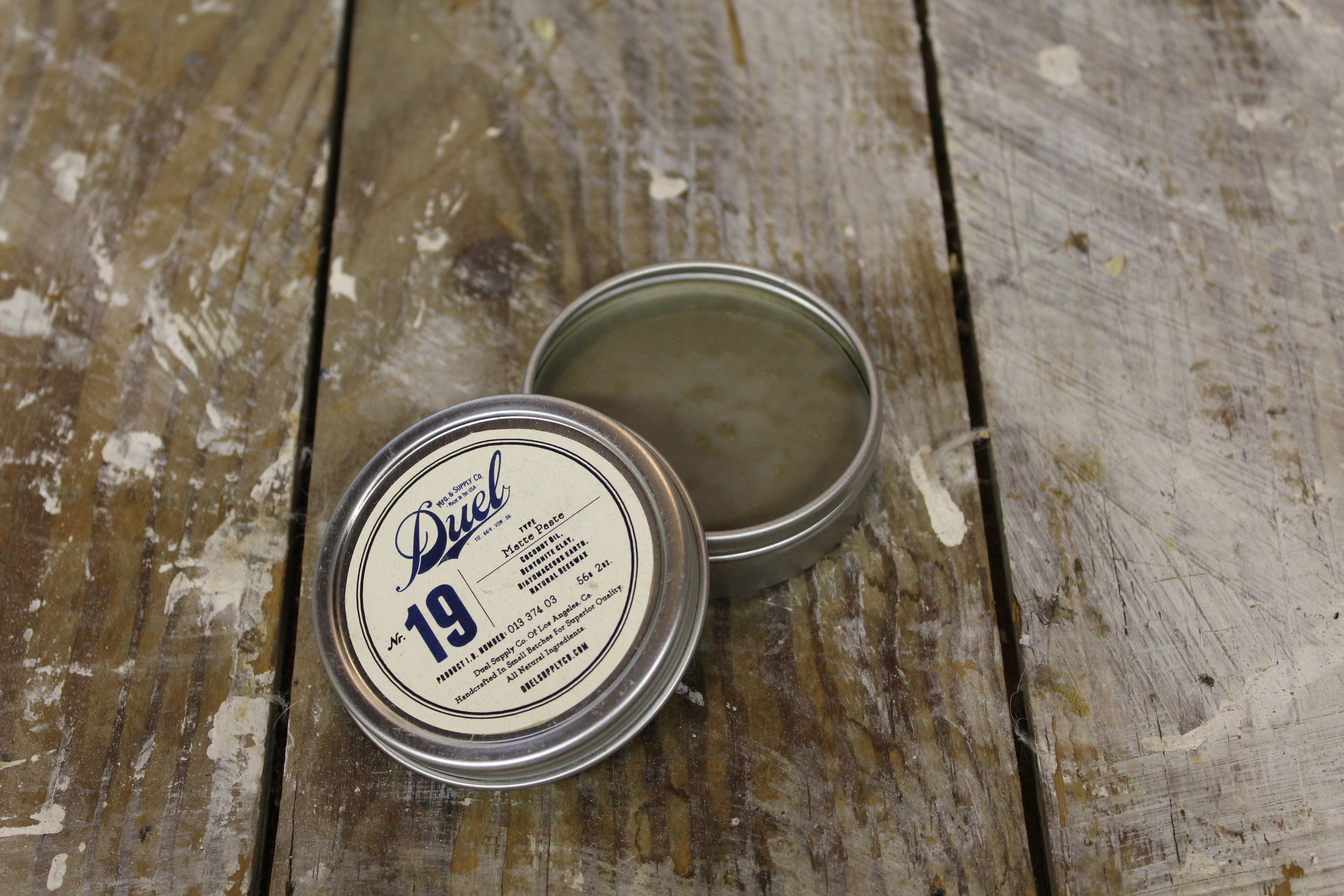Duel Matte Clay Paste No. 19 — open tin on raw wood