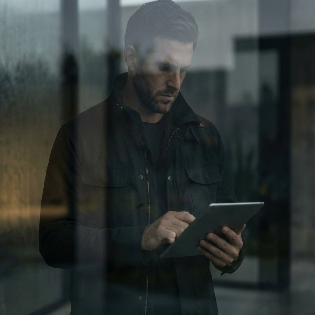 Durindal founder at window with tablet — glass reflection